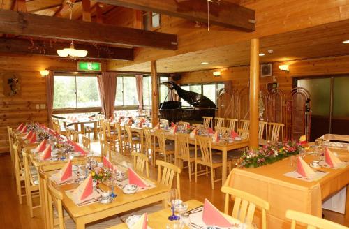 a dining room with tables and chairs and a piano at Soratobu Usagi in Myoko