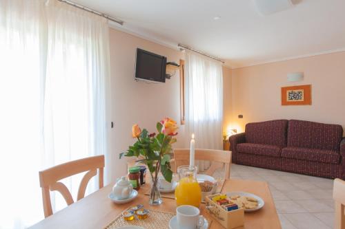 a living room with a table with a candle and a couch at Residence Hotel Raggio Di Luce in Ponte di Legno