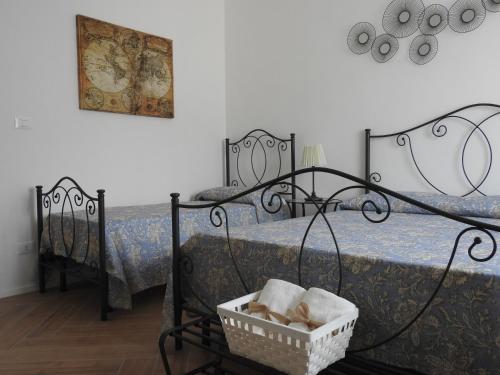 a bedroom with two beds and a basket of towels at Casa Pinco in Siracusa