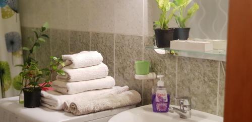 a bathroom with towels on a sink and a mirror at Gran canaria (arinaga) in Arinaga