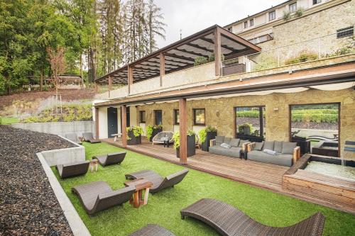 a house with a patio and a yard with furniture at Wellness & spa hotel Augustiniánský dům in Luhačovice
