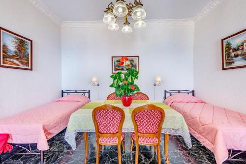 a dining room with a table and pink chairs at Veranda Syros House in Ermoupoli