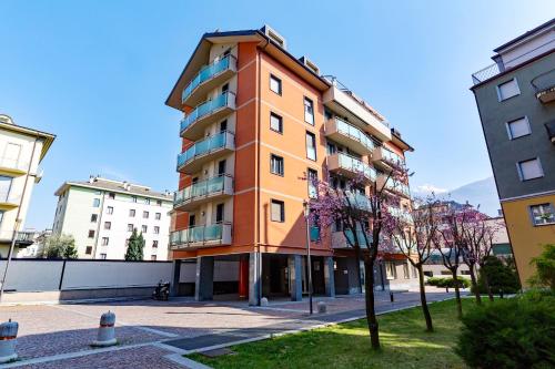 a tall orange building in the middle of two buildings at Residenza CONCORDIA in Sondrio