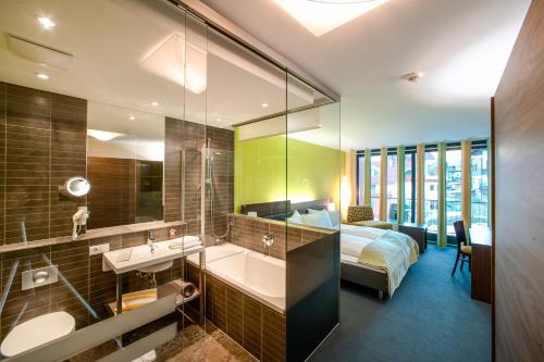 a bathroom with a sink and a bed in a room at Josl Mountain Lounging Hotel - Adults only! in Obergurgl
