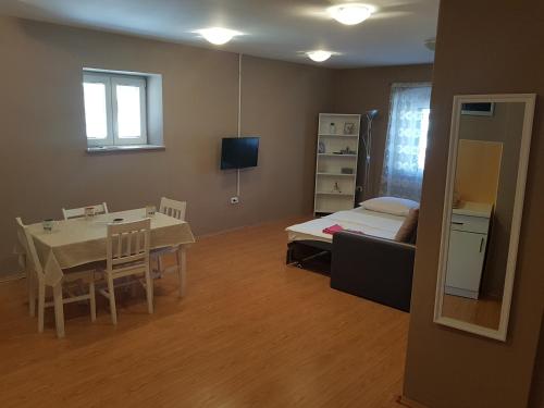 ein Wohnzimmer mit einem Tisch und einem Bett sowie ein Esszimmer in der Unterkunft Apartment Central in Šibenik
