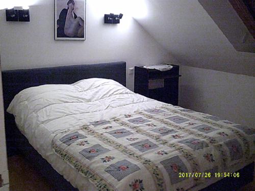 1 dormitorio con 1 cama con edredón en Soizic' house en Trébeurden