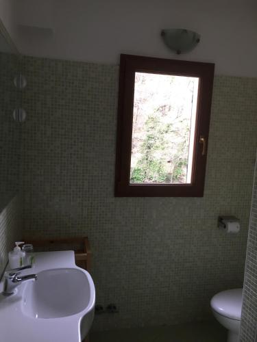 a bathroom with a sink and a window at The River House in Agaggio Inferiore