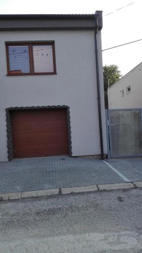 a white garage with a brown garage door at Halex 3 in Bojná
