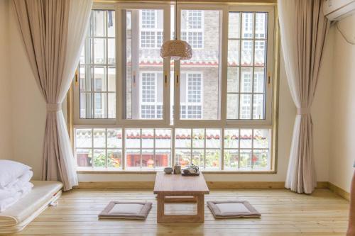 a living room with a large window and a table at Bloom Time Guest House in Dujiangyan