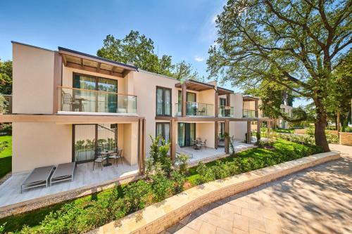 an exterior view of a house with a patio at Garden Suites Umag Plava Laguna in Umag