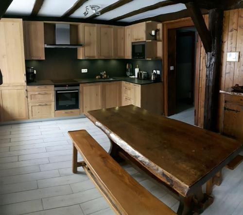 a large kitchen with a wooden table and a bench at Appartement avec Terrasse in Chamonix-Mont-Blanc