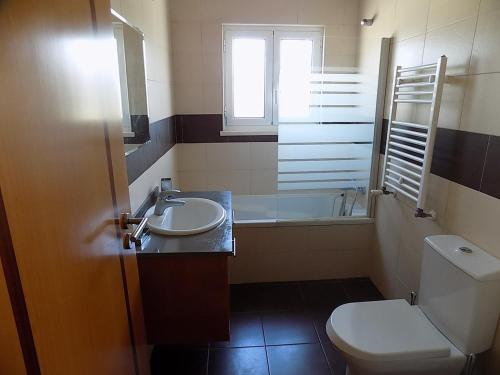 La salle de bains est pourvue de toilettes, d'un lavabo et d'une baignoire. dans l'établissement Casa Foz, à Foz do Arelho