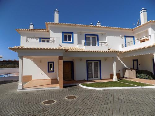 a white house with blue windows and a driveway at Casa Foz in Foz do Arelho