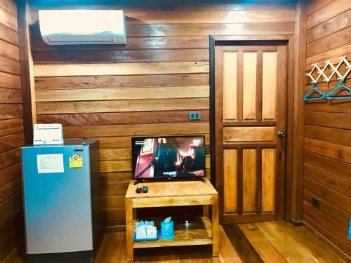 una TV in camera con parete in legno di We Care Resort a Wi-jiērn