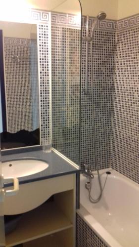 une salle de bain avec un lavabo, une baignoire et un miroir dans l'établissement Terrasse sur Green Port Bourgenay, à Talmont-Saint-Hilaire