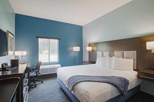 Habitación de hotel con cama grande y escritorio. en Iris Garden Inn, en Savannah