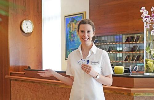 a woman standing in front of a counter at Hotel Du Lac et Bellevue in Bardolino