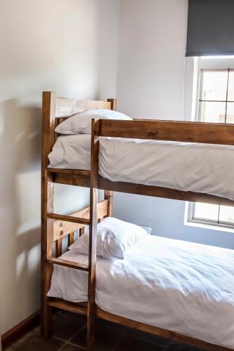 two bunk beds in a room next to a window at Blue Rain Guest House in Bloemfontein