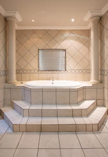 a large bathroom with a tub and stairs at Spacube Luxury Suites and Spa in Pretoria