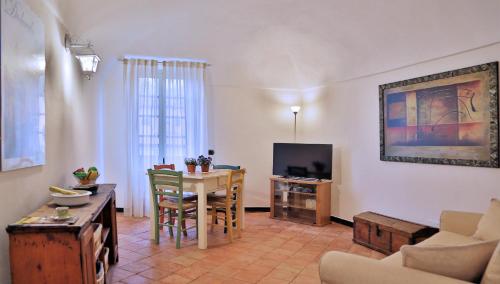 ein Wohnzimmer mit einem Tisch und einem TV in der Unterkunft Sarazenenturm Franco in Dolcedo