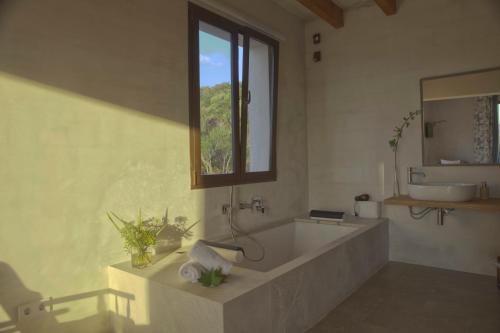 a large bathroom with a tub and a window at El Encinar de Arta in Artá