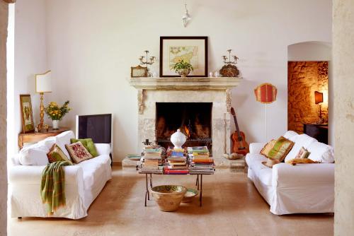 sala de estar con 2 sofás blancos y chimenea en Baglio Occhipinti, en Vittoria