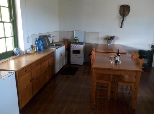 a kitchen with wooden floors and a table and a stove at Infinity farm in Riversdale
