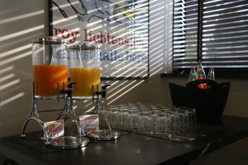 a table with glasses and a pitcher of orange juice at Hotel Motel Ascot in Lissone