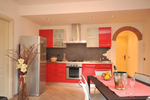a kitchen with red cabinets and a table with a dining room at VILLA VINICIA, pool, jacuzzi, airco in Domaso