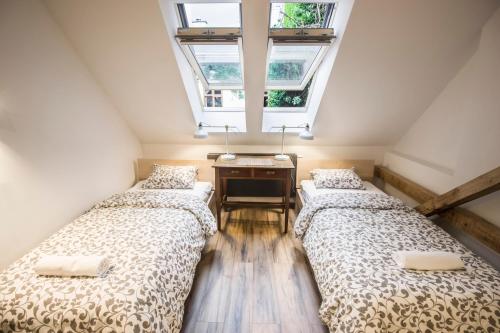 two beds in a room with a window at Sewa Apartments in Krakow