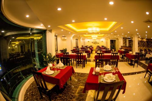 a restaurant with red tables and chairs in a room at Le Bordeaux Sapa Hotel in Sa Pa