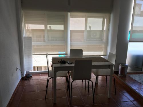 une salle à manger avec une table et des chaises et une fenêtre dans l'établissement Piso Coqueto, à Alicante