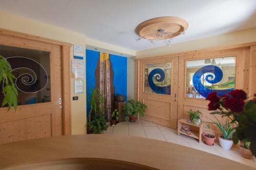 a dining room with paintings on the walls and plants at Residence Hotel Raggio Di Luce in Ponte di Legno