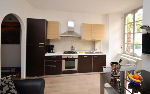 a kitchen with brown cabinets and a black refrigerator at VILLA VINICIA, pool, jacuzzi, airco in Domaso