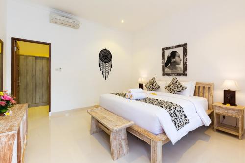 a bedroom with a large bed and a table at Amerta Seminyak in Seminyak