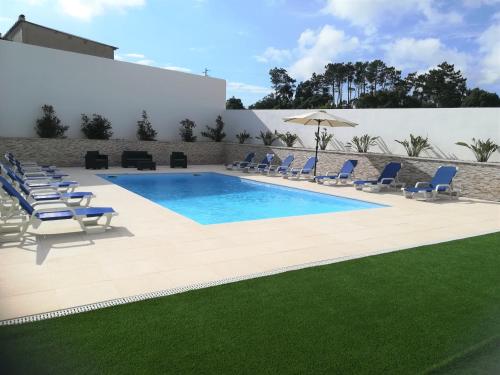 einen Pool mit Liegestühlen und einem Pool in der Unterkunft Alojamentos Campo & Mar - Vivenda Golden House in Bica