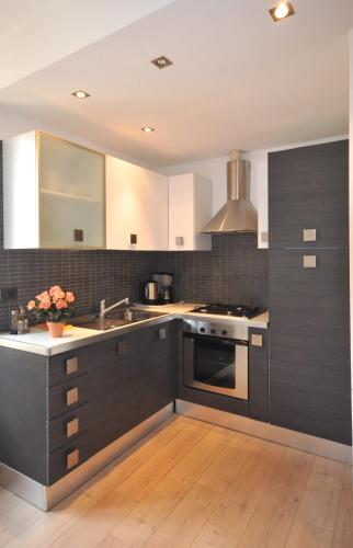 a kitchen with black and white cabinets and a sink at VILLA VINICIA, pool, jacuzzi, airco in Domaso