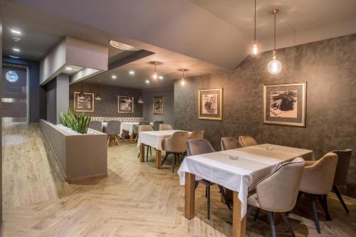 a dining room with white tables and chairs at Hotel Bigeste in Ljubuški