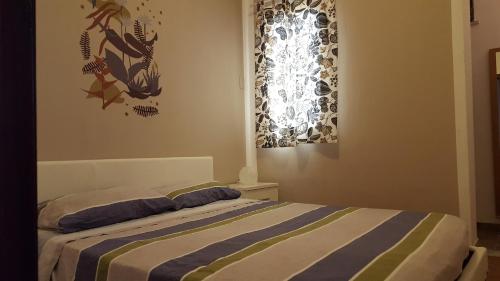 een slaapkamer met een bed met een gestreepte deken bij Mediterranean in Terrasini
