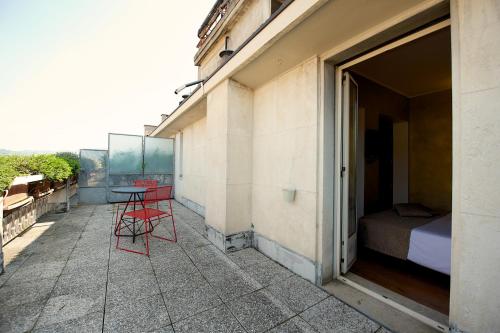 a patio with two red chairs and a table on a building at Best Western Hotel Luxor in Turin