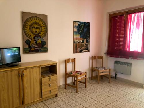 プリンチピナ・ア・マーレにあるGirino IIのリビングルーム(テレビ、椅子2脚付)