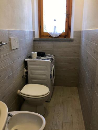 a bathroom with a toilet and a sink and a window at Girino II in Principina a Mare