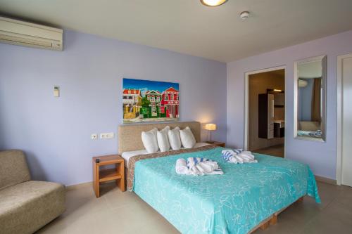 a bedroom with a bed with two towels on it at Blue Bay Apartments in Sint Michiel