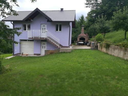 a purple house with a garage and a gazebo at Vacation home Djogic in Ilidza