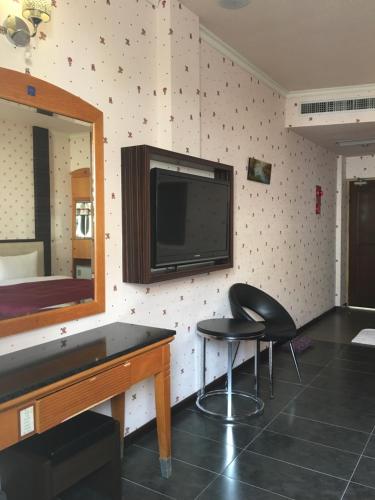 a room with a flat screen tv on a wall at Treasure Island Motel - Renwu in Kaohsiung