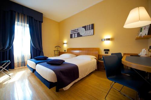 a hotel room with a bed and a desk at Best Western Hotel Luxor in Turin