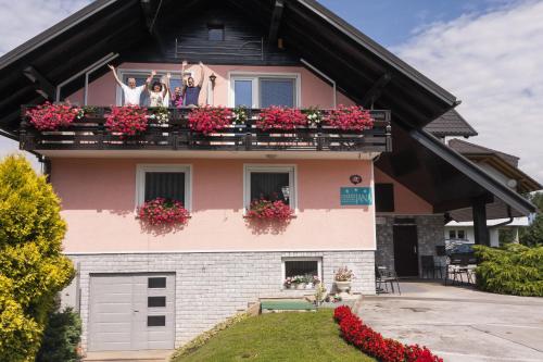 two dogs on a balcony of a house with flowers at Rooms & Apartments Jana in Cerklje na Gorenjskem