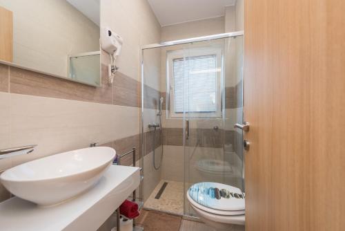 a bathroom with a sink and a toilet and a shower at Apartments Bracic Spa in Sukošan