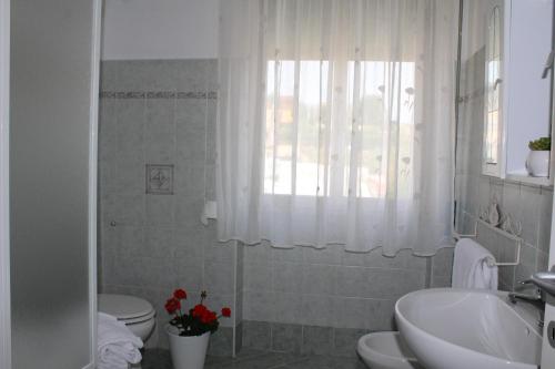 uma casa de banho com 2 WC, um lavatório e uma janela em Casa Nicolas em Roma