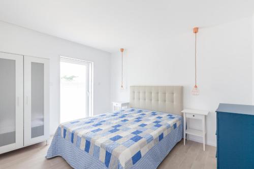 um quarto branco com uma cama e uma janela em Blue Dreams em Ovar